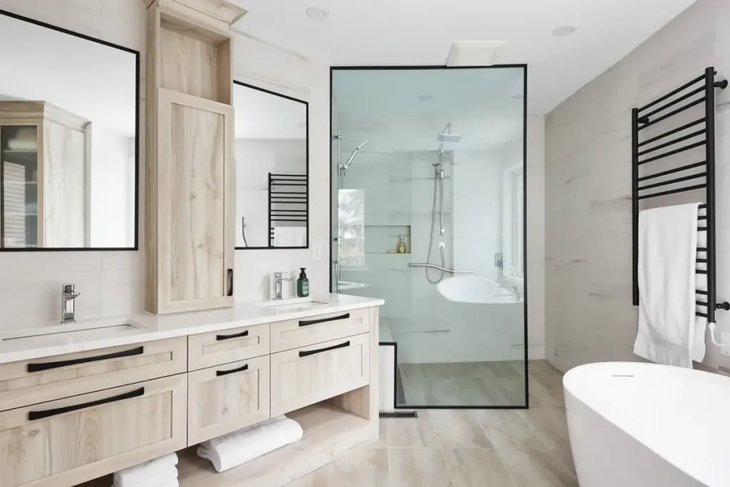 A stylish bathroom featuring a natural wood double vanity, glass-enclosed shower, and freestanding tub, showcasing modern design elements.