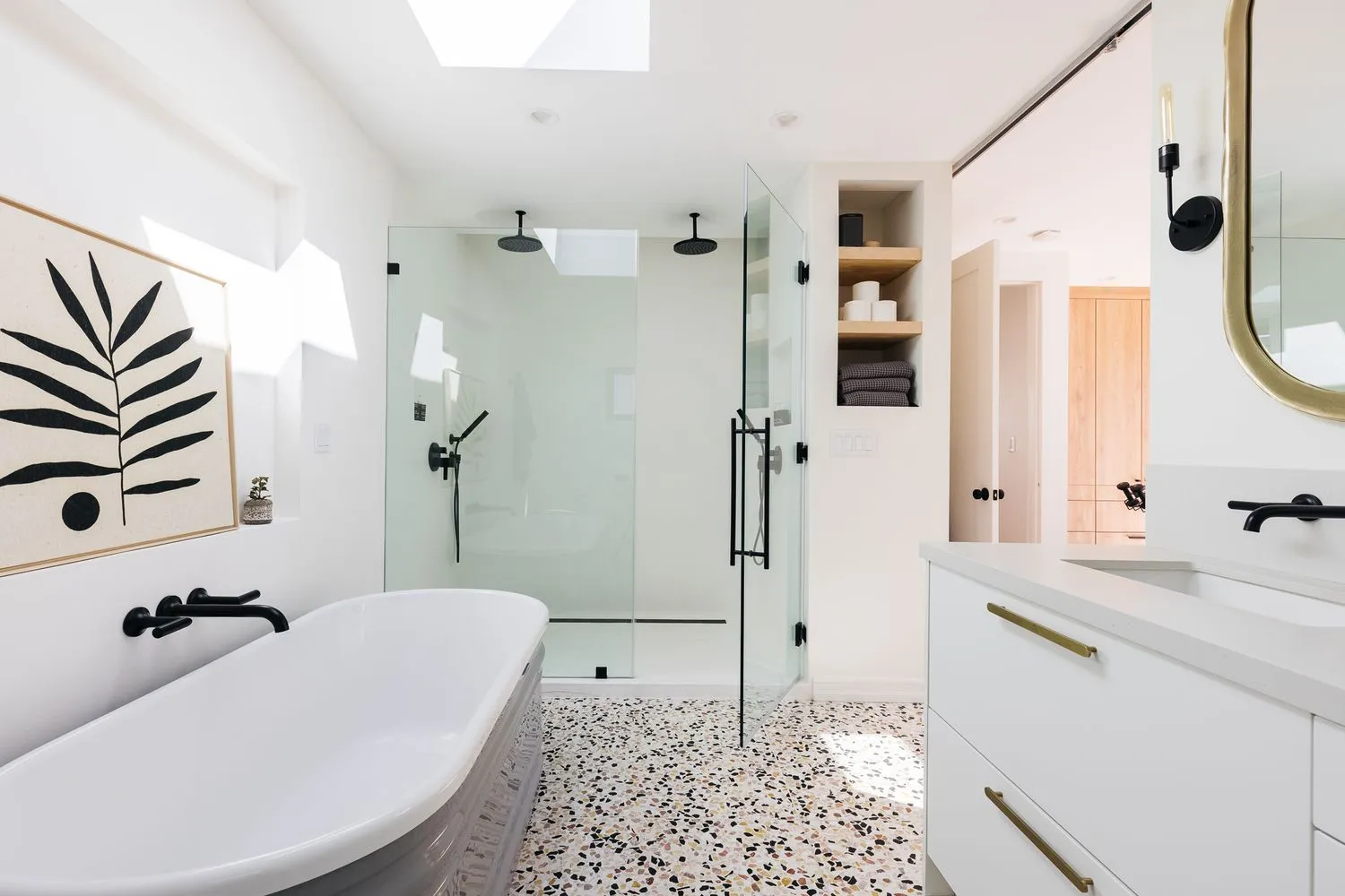 A modern bathroom with minimalist design, white finishes, black fixtures, and custom gray-and-black floor tiles.