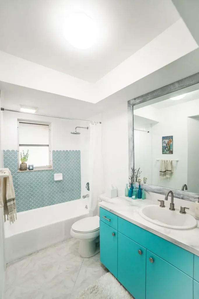 Coastal-style bathroom remodel with teal vanity and modern decor in Tamarac, FL