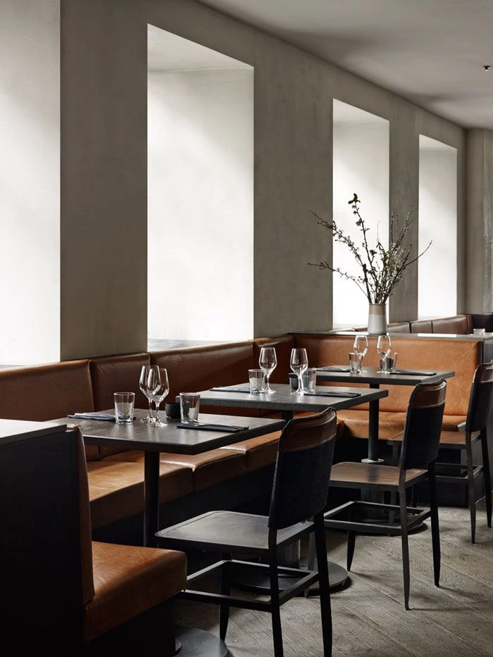 A modern restaurant with minimalistic design, featuring sleek tables, chairs, and a uniform layout.