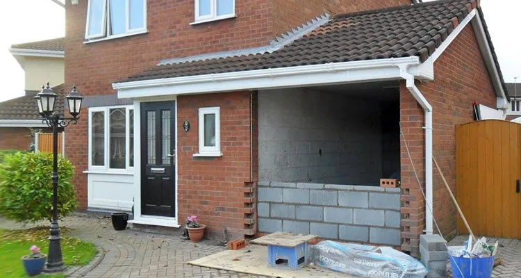 Partially converted garage under construction with brickwork and foundational upgrades.